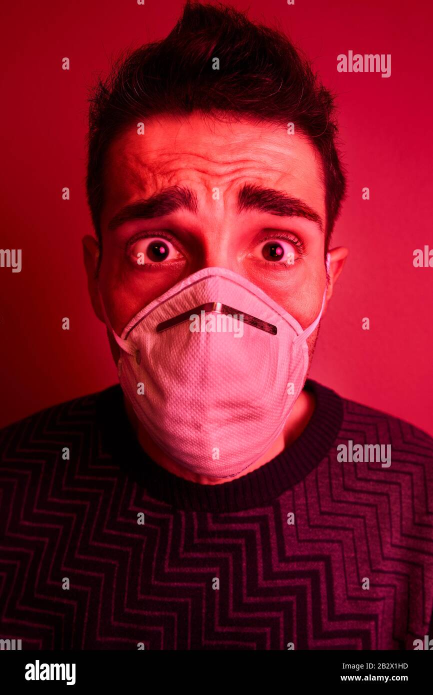 Scared man with a face mask in a danger environment Stock Photo