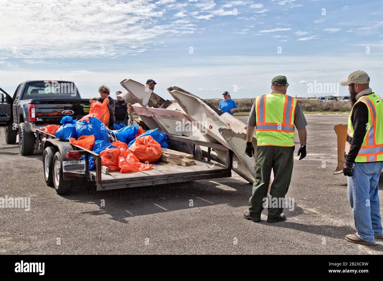Trailer loaded with marine debris & shoreline trash collected by volunteers, unloading by park personel & participants. Stock Photo
