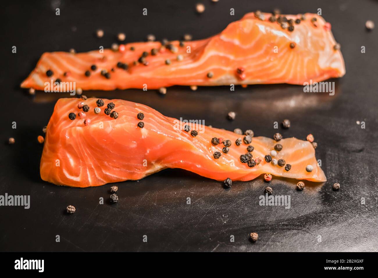 Raw sea red salmon fish fillet on black background. View from above ...