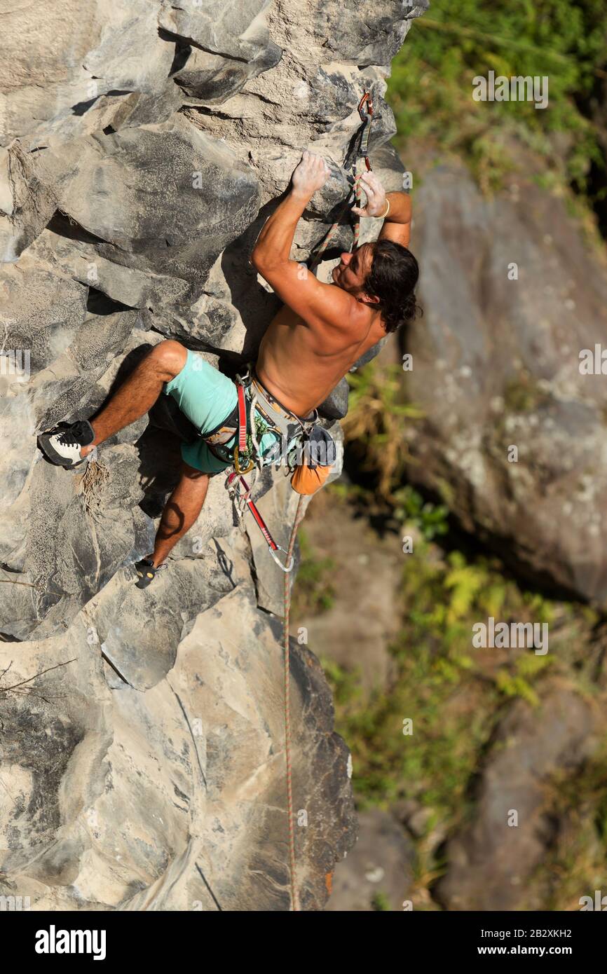 Rock Climber Climbing Up A Cliff Stock Photo