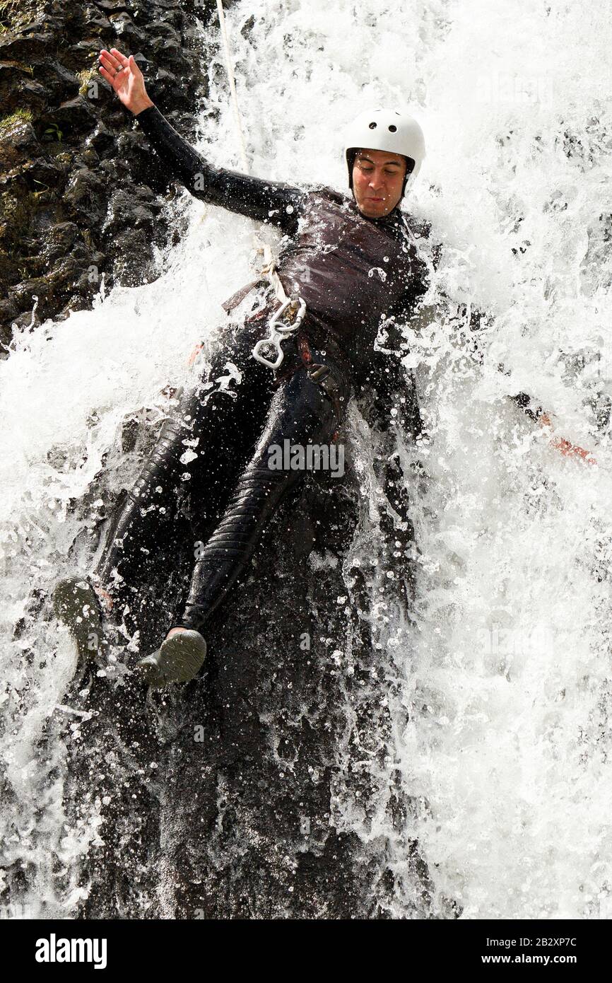 Mature Man Descending Into A Waterfall Shoot From The Wet Position Stock Photo