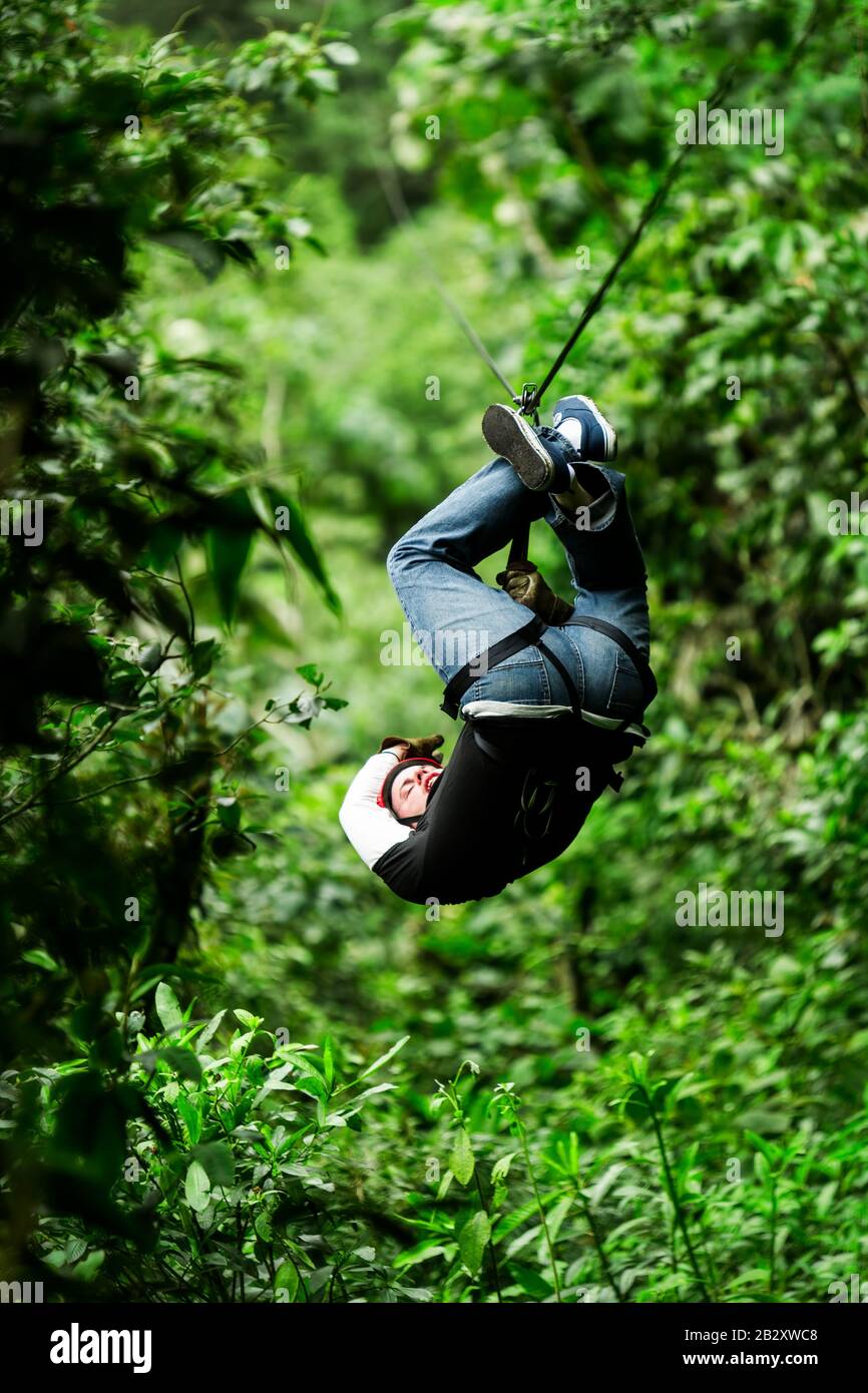 Adult Male Visitor Wearing Informal Clothing On Zip Line Or Canopy Experience In Ecuadorian Rain Forest Stock Photo