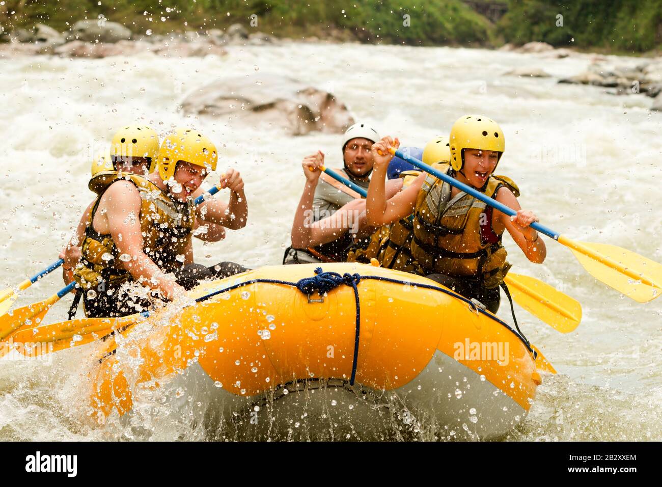 Crowd Of Mixed Mountaineer Men And Women With Guided By Professional Pilot On Whitewater Waterway Rafting In Ecuador Stock Photo
