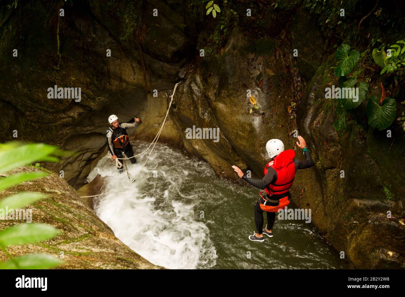 Well Prepared Man Jumping Into A Natural Pool During A Canyoning Expedition Stock Photo