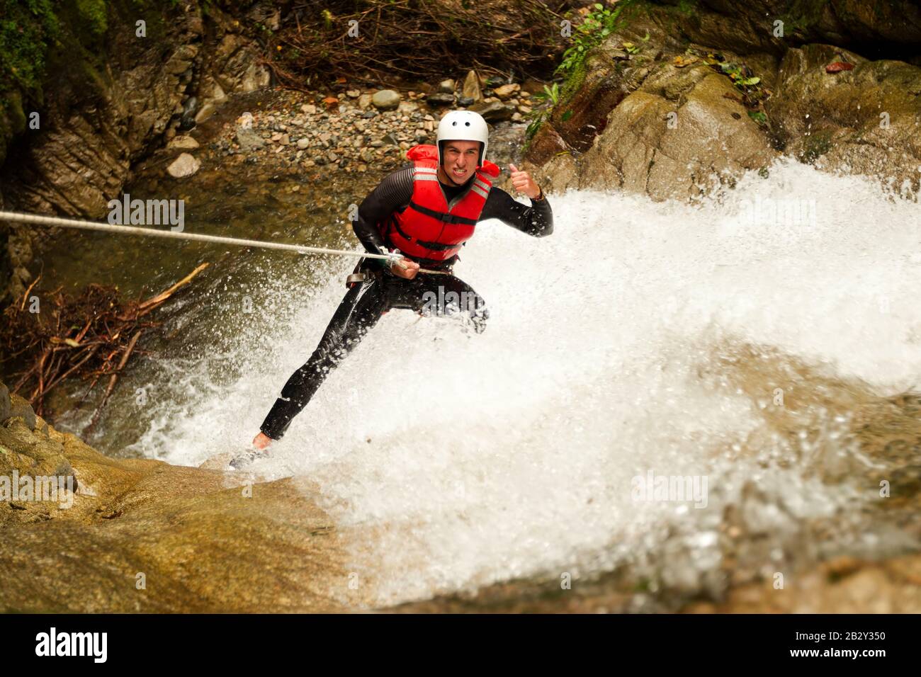 Adult Man Wearing Tight Equipment Descending A Waterfall Stock Photo