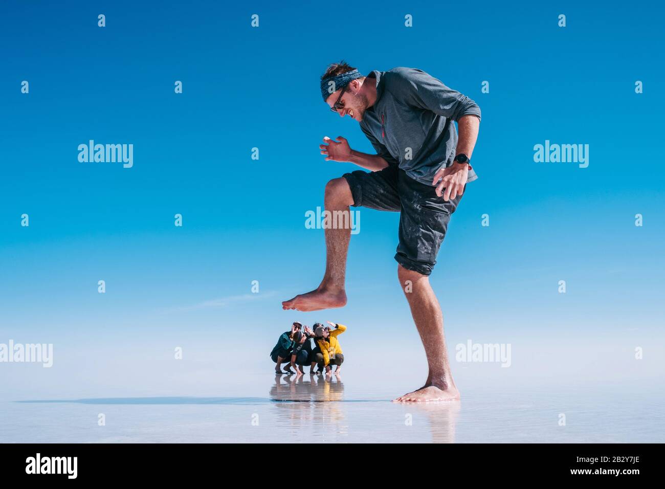 Tourists at Uyuni Salt Flats (Spanish: Salar de Uyuni ) in Bolivia, South America, forced perspective. Stock Photo