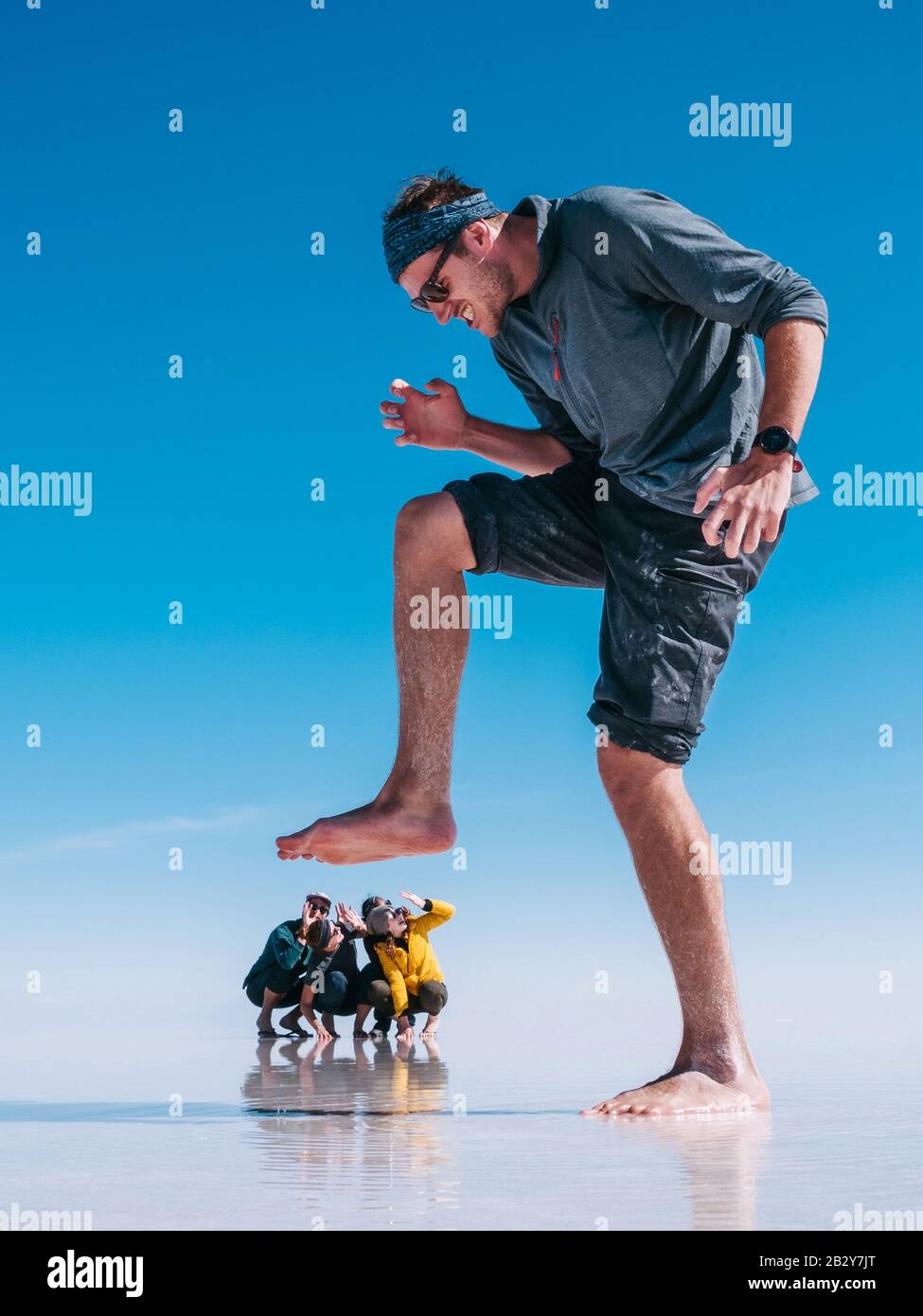 Tourists at Uyuni Salt Flats (Spanish: Salar de Uyuni ) in Bolivia, South America, forced perspective. Stock Photo