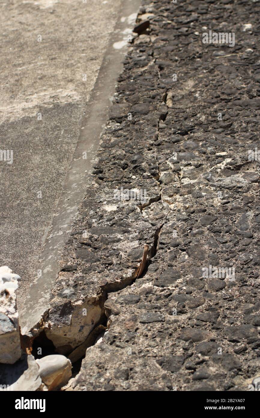 Crack in concrete floor slab, next to flexible joint. Stock Photo