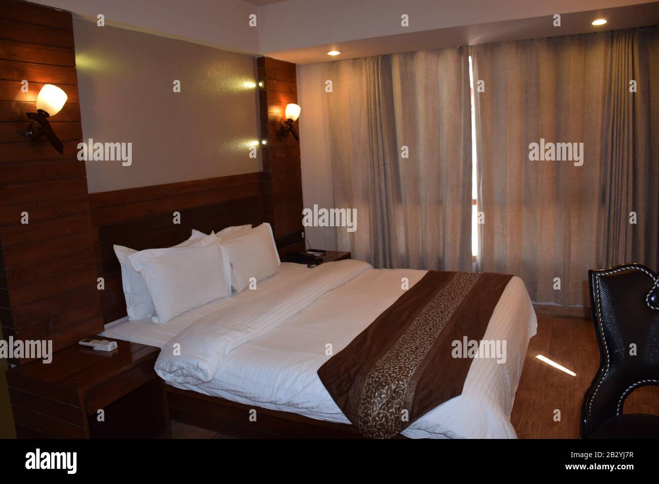 Standard hotel bed room with light on Stock Photo