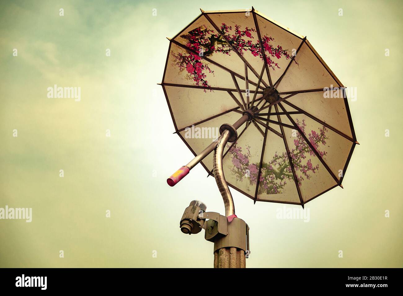 Decorative lamp post in the shape of a Chinese Umbrella on yellow sky