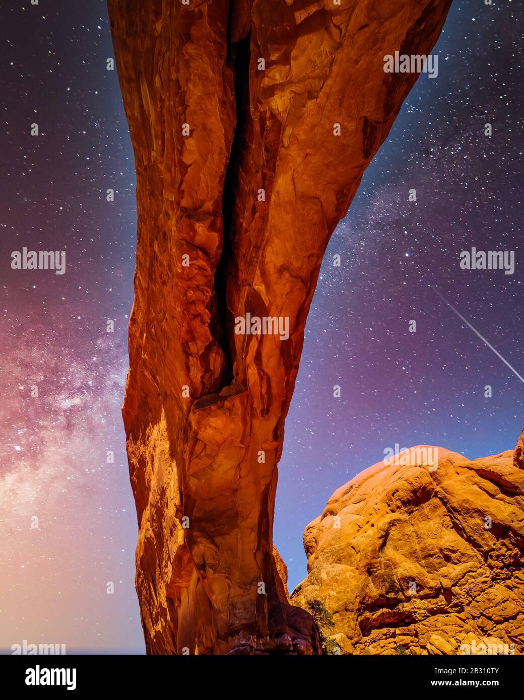 The night sky and milky way over the delicate Sandstone Arch of the North Window Arch, one of the many large Sandstone Arches in Arches National Park Stock Photo