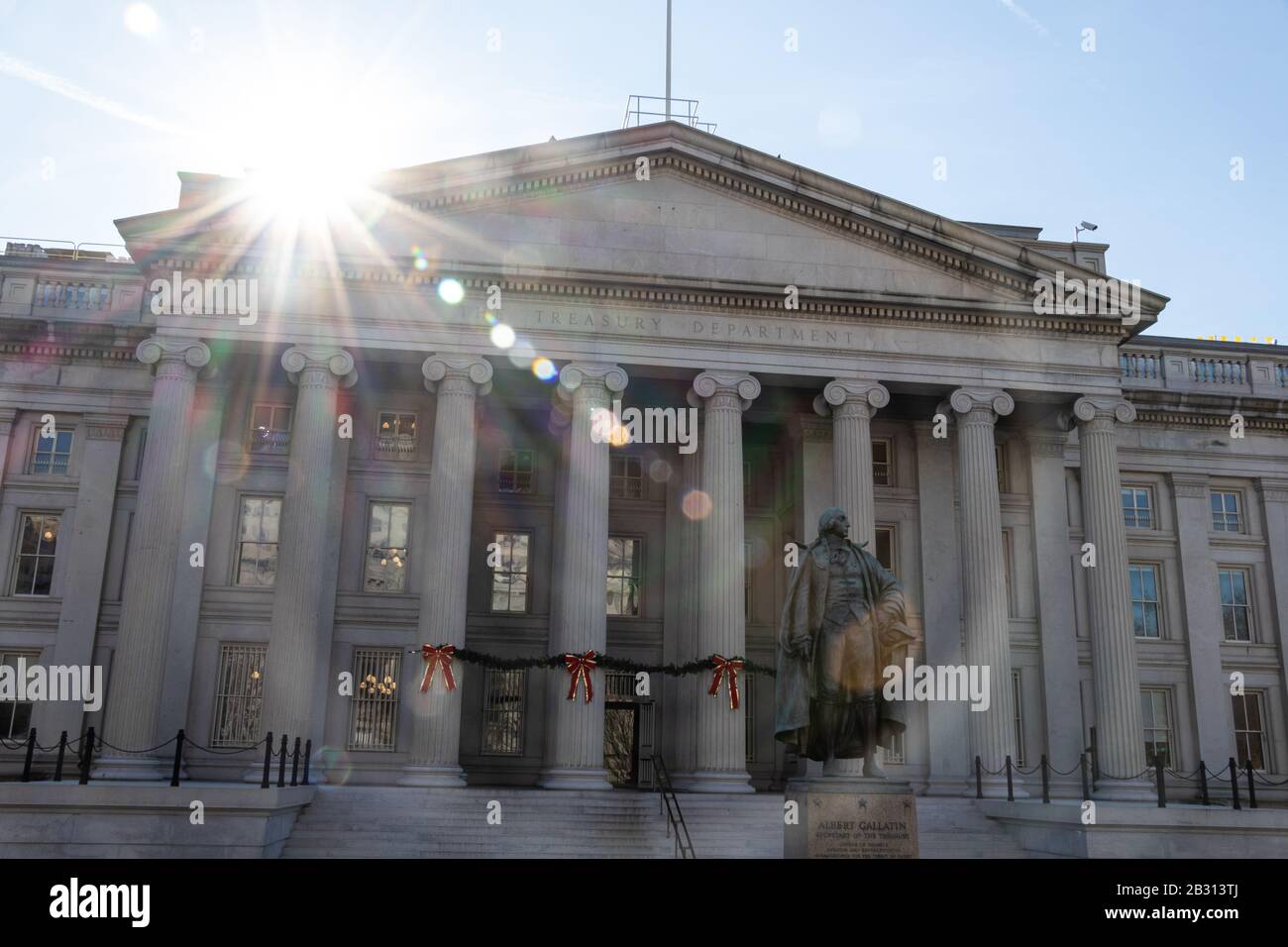 Sun glaring down on The Treasury Building, home to the US Department of Treasury. Bronze statue