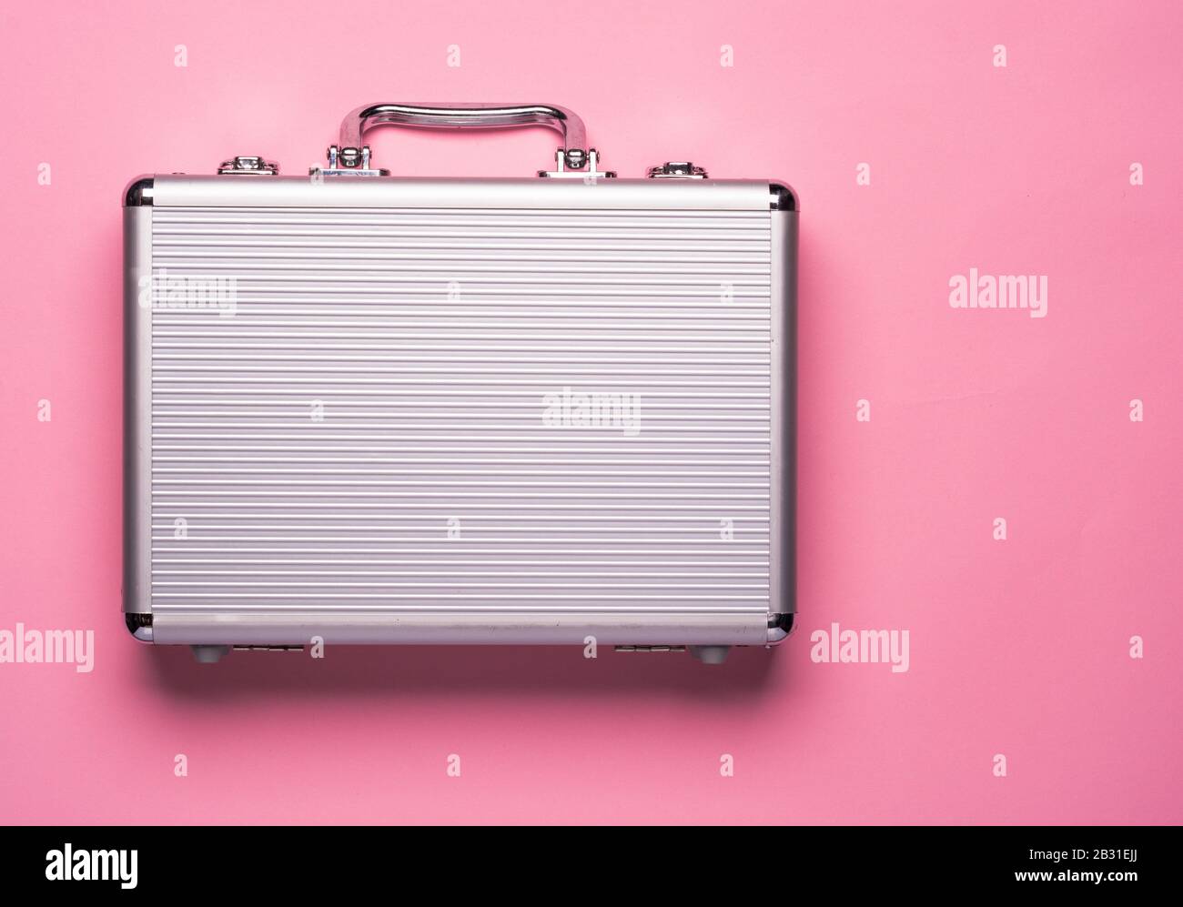 Contemporary aluminum briefcase on pink background. Flat lay concept