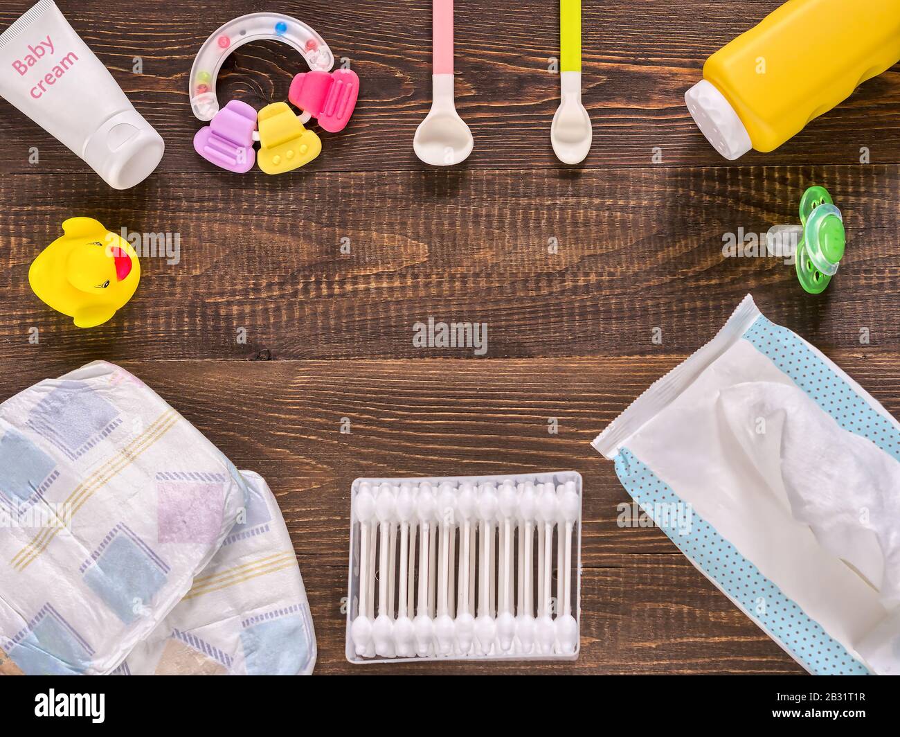 Japanese diapers, wet wipes, baby powder, cream, tither, cotton buds,  spoons, soother and duckling on wooden background. Flat lay. Text font from  open sources, free license of use Stock Photo - Alamy