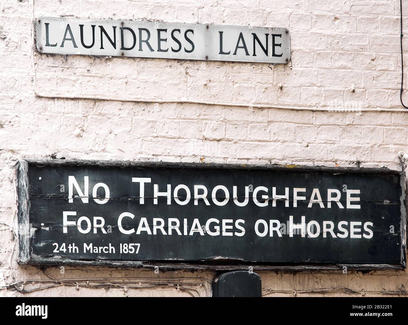 Road sign, 1857, in Laundress Lane, Cambridge, England, informing travellers that there is no thoroughfare for carriages or horses. Stock Photo
