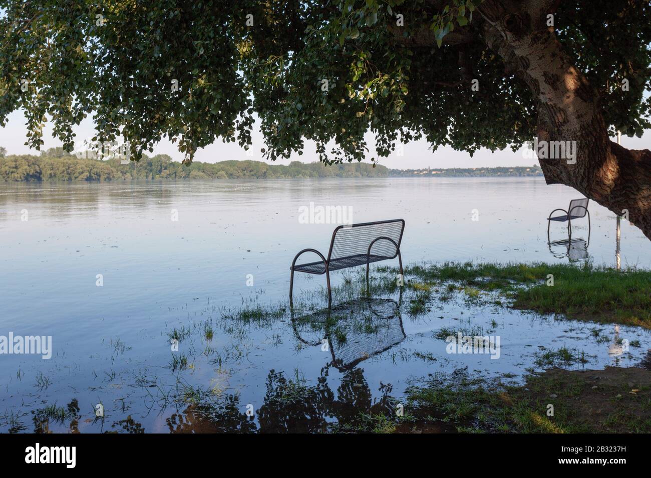 Flooded riverfront and the bench in Vukovat town od the Danube River, Croatia Stock Photo