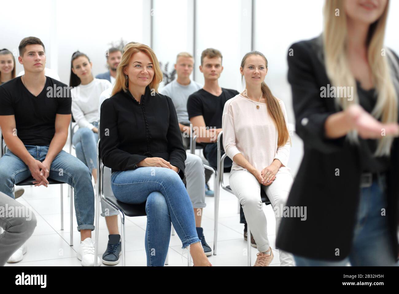 group of diverse young people sitting in a conference room Stock Photo ...