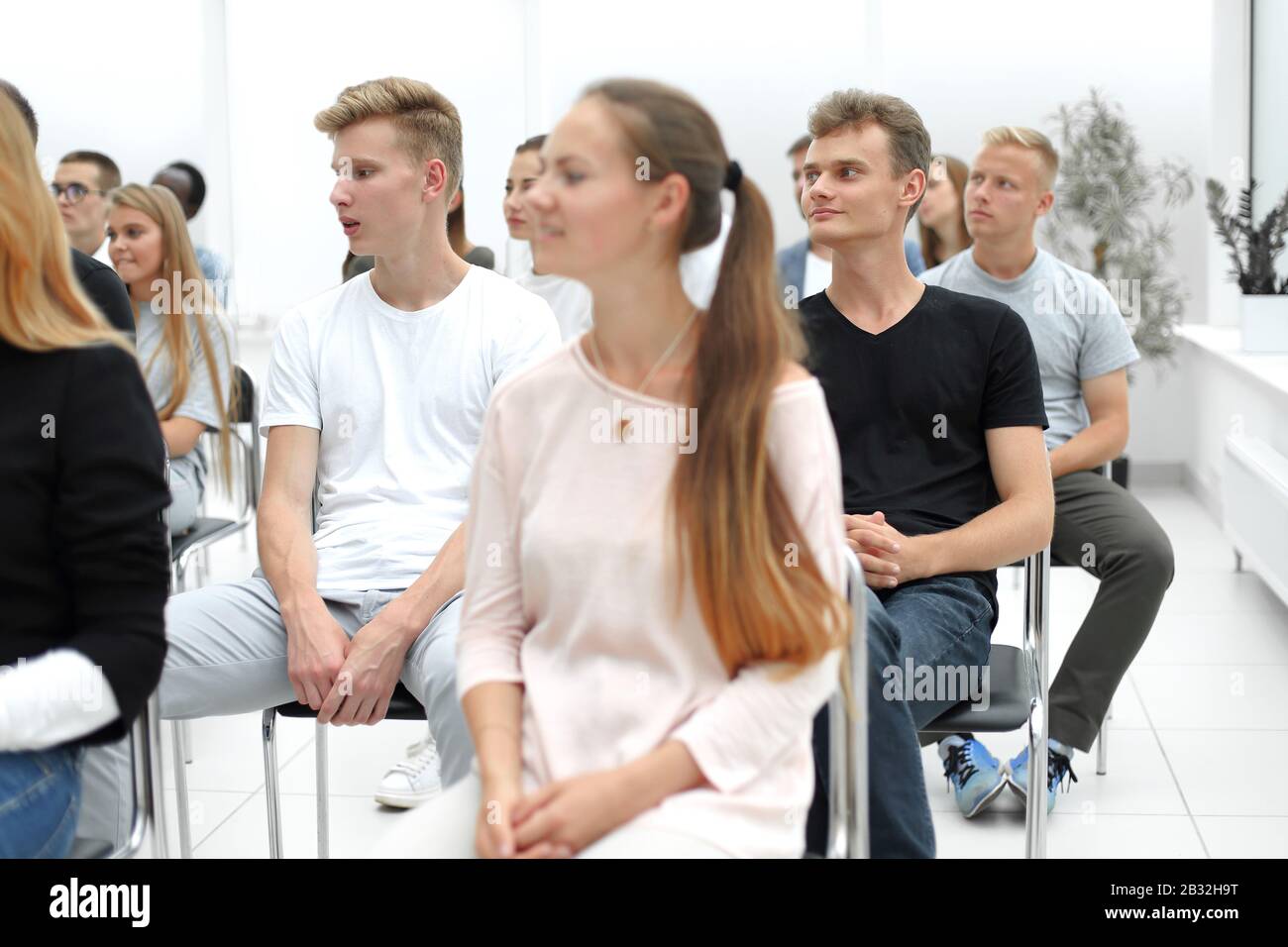 group of diverse young people sitting in a conference room Stock Photo ...