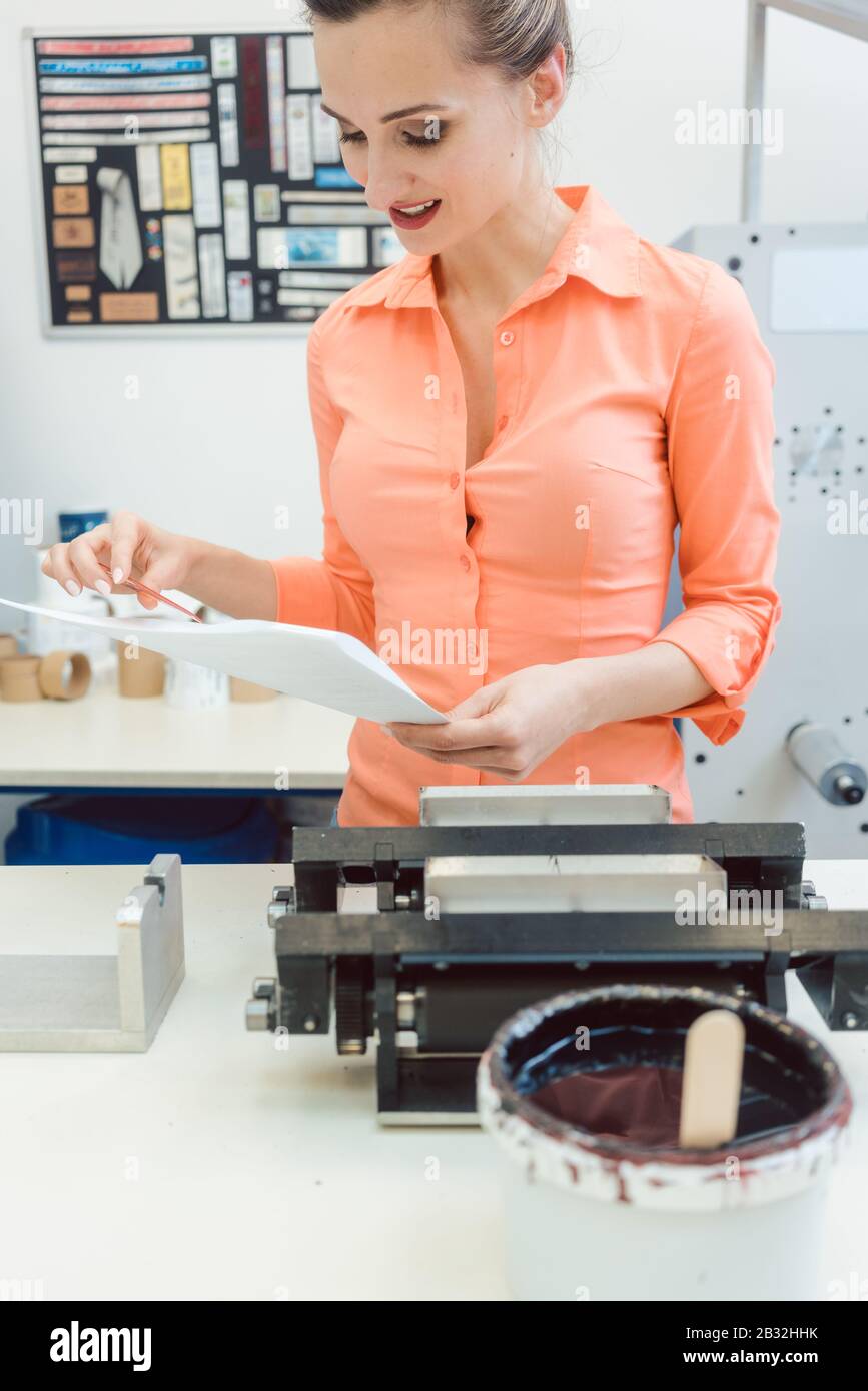 Worker checking design or a print to be run on printing machine Stock Photo