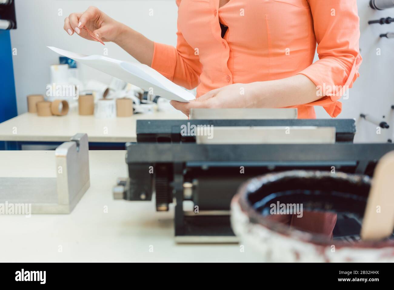 Worker checking design or a print to be run on printing machine Stock Photo
