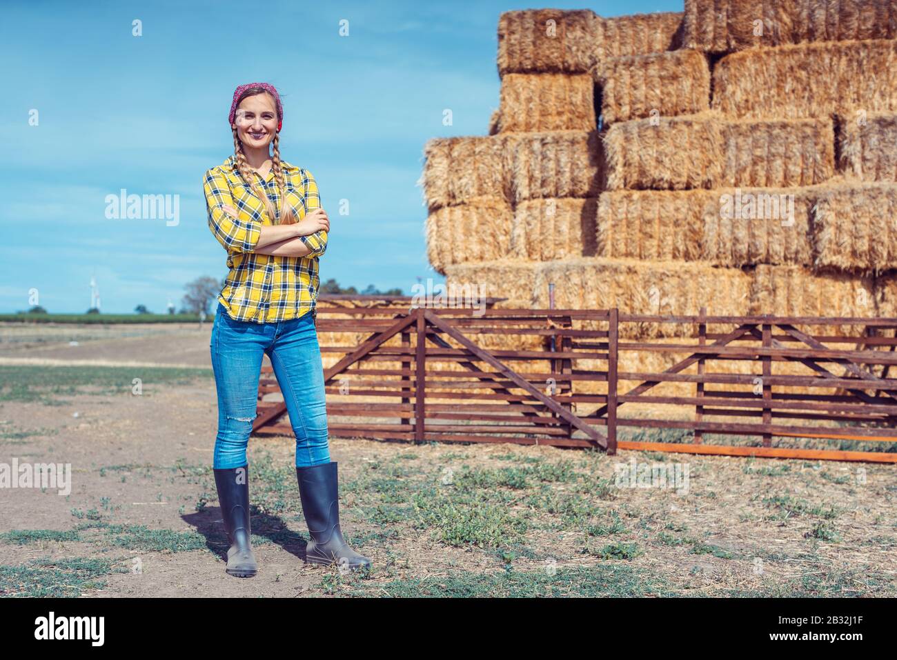 Farmer woman on her farm standing in front of straw Stock Photo - Alamy