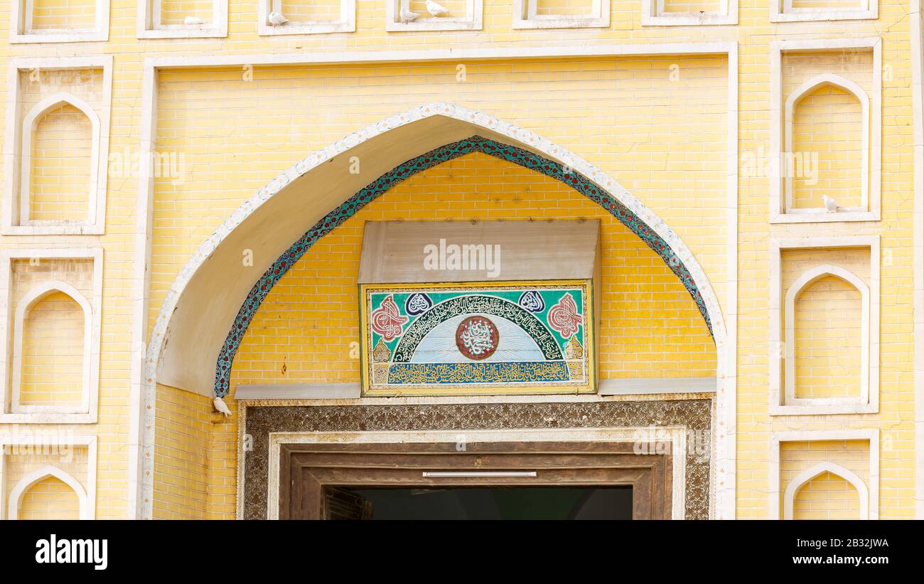 Detail of entrance gate to Id Kah Mosque. Characteristic arch & arabic inscriptions. Many people of the Uyghur minority in China are muslims. Stock Photo