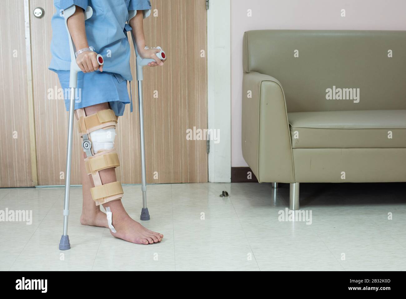 Asian woman patient with knee brace with walking stick and knee braces