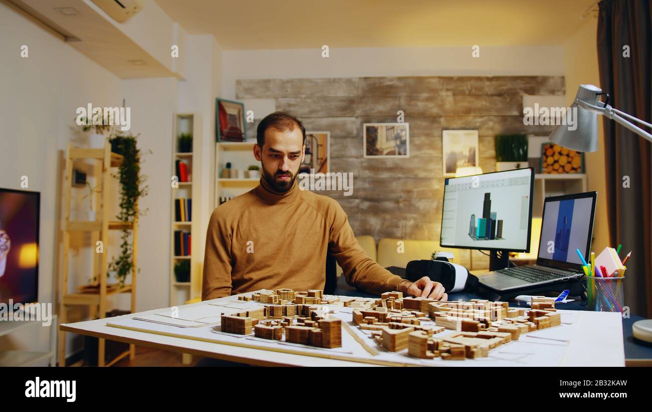 Young architect using augmented reality holograms for his building models. Stock Photo
