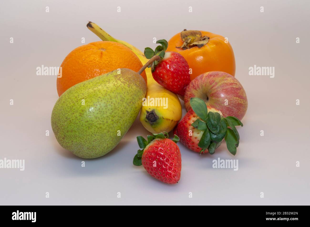 Strawberry, Pear Rock, Banana, Apple, Orange, Persimmon. Varied fruit essential for a healthy and balanced diet. Stock Photo