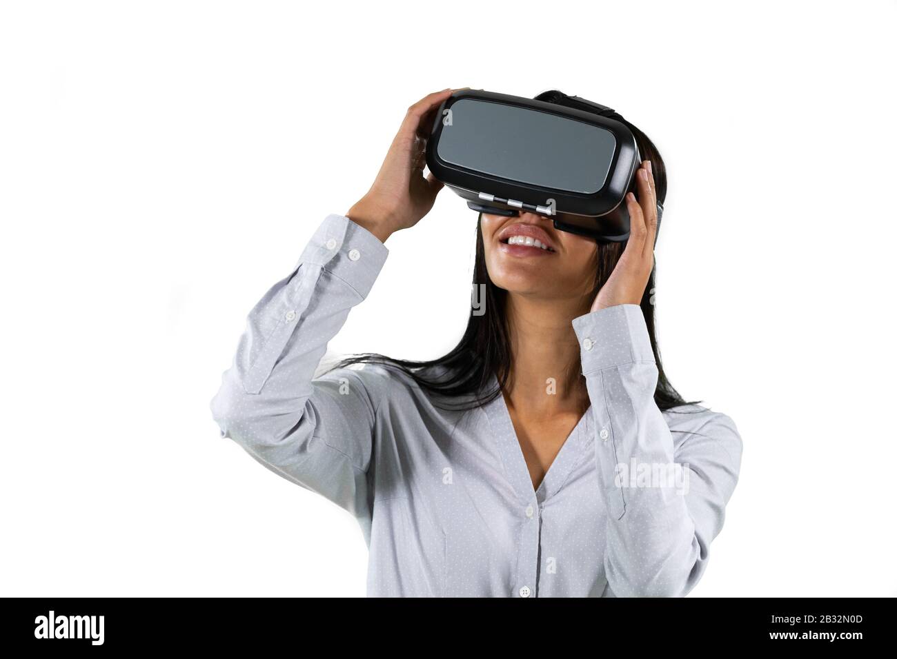Mixed race business woman wearing a Virtual Reality headset Stock Photo
