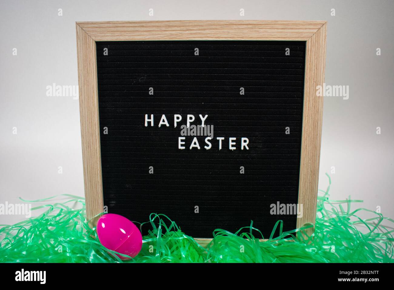 A Black Happy Easter Sign With White Letters Easter Grass and Easter