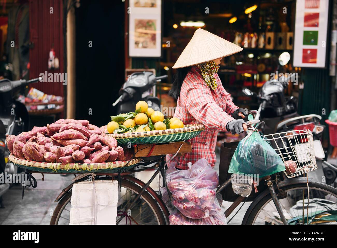 Vietnamese woman with bike selling tropical fruit at the market Stock Photo