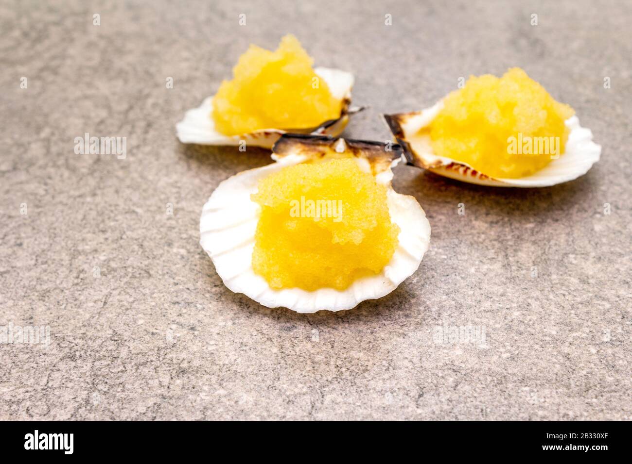 Capelin roe in seashells. Lightly salted caviar snack on a stone ...