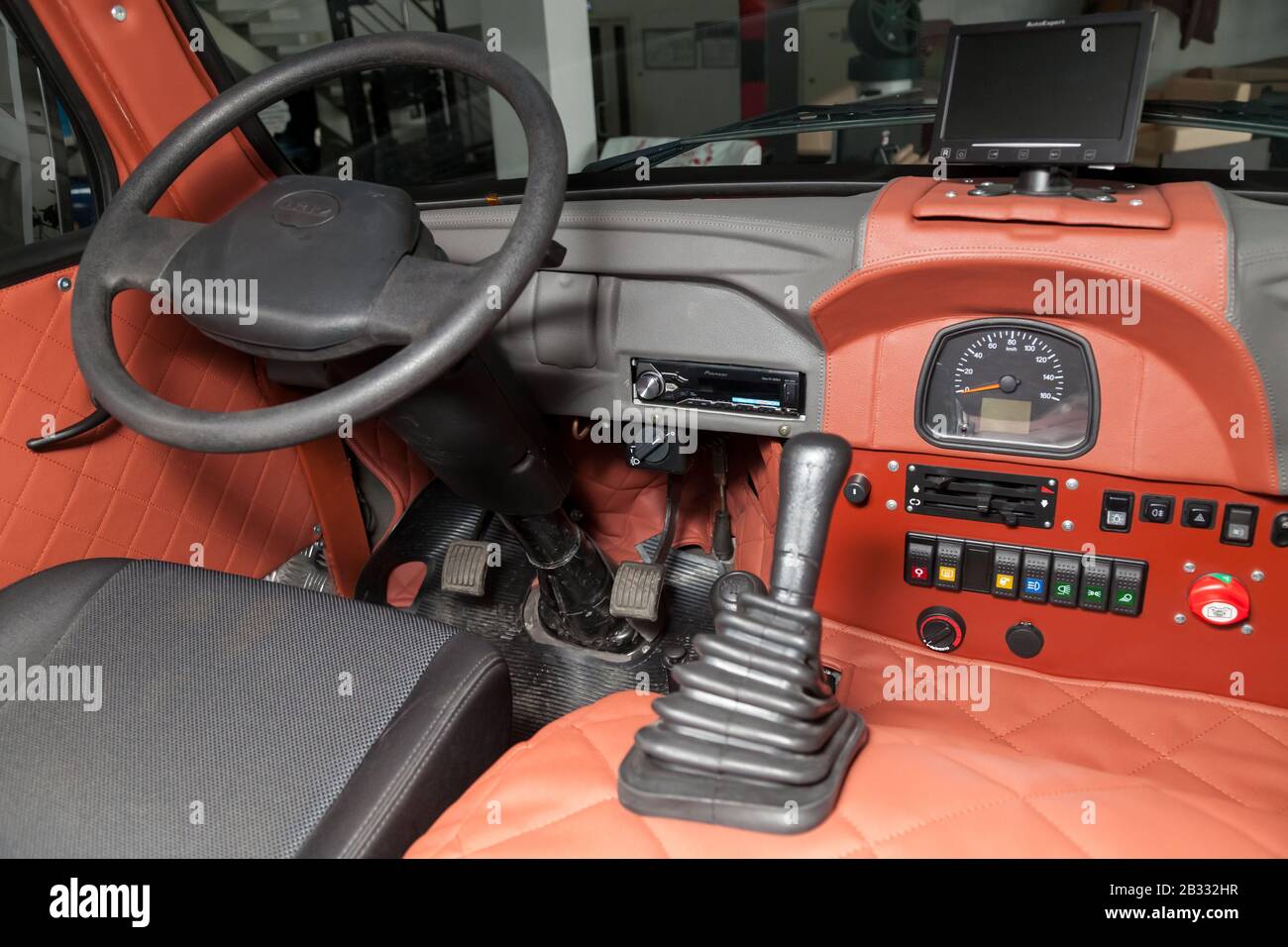 Novosibirsk, Russia - 02.26.2020: Red interior of used UAZ VAN 452 469 car with dashboard, steering wheel, and front seats prepared for off road drive Stock Photo