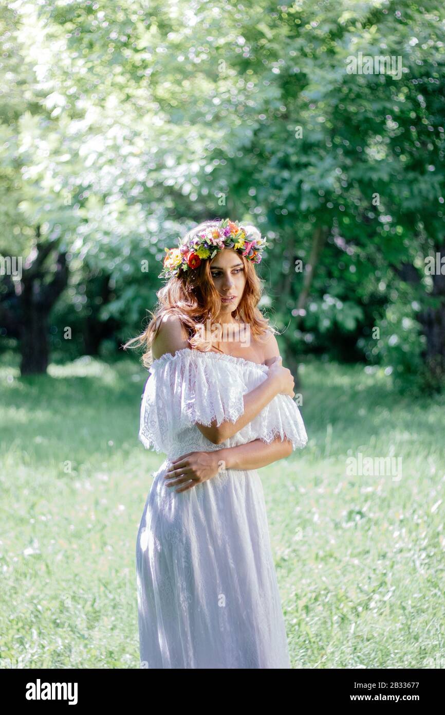 Bride in a wedding dress staying on the green forest Stock Photo - Alamy