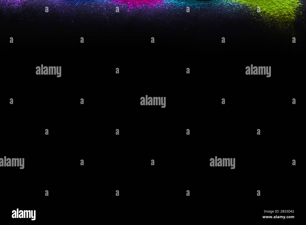 Multi-colors powder sprayed on black background. Holi celebration Stock Photo