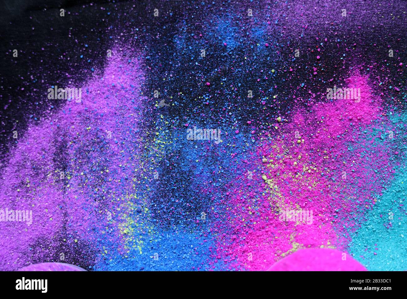 Multi-colored powder sprayed on black background. Holi celebration Stock Photo