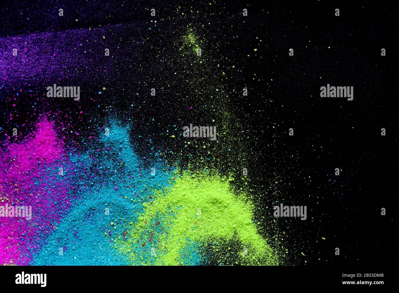 Multi-colored powder sprayed on black background. Holi celebration Stock Photo