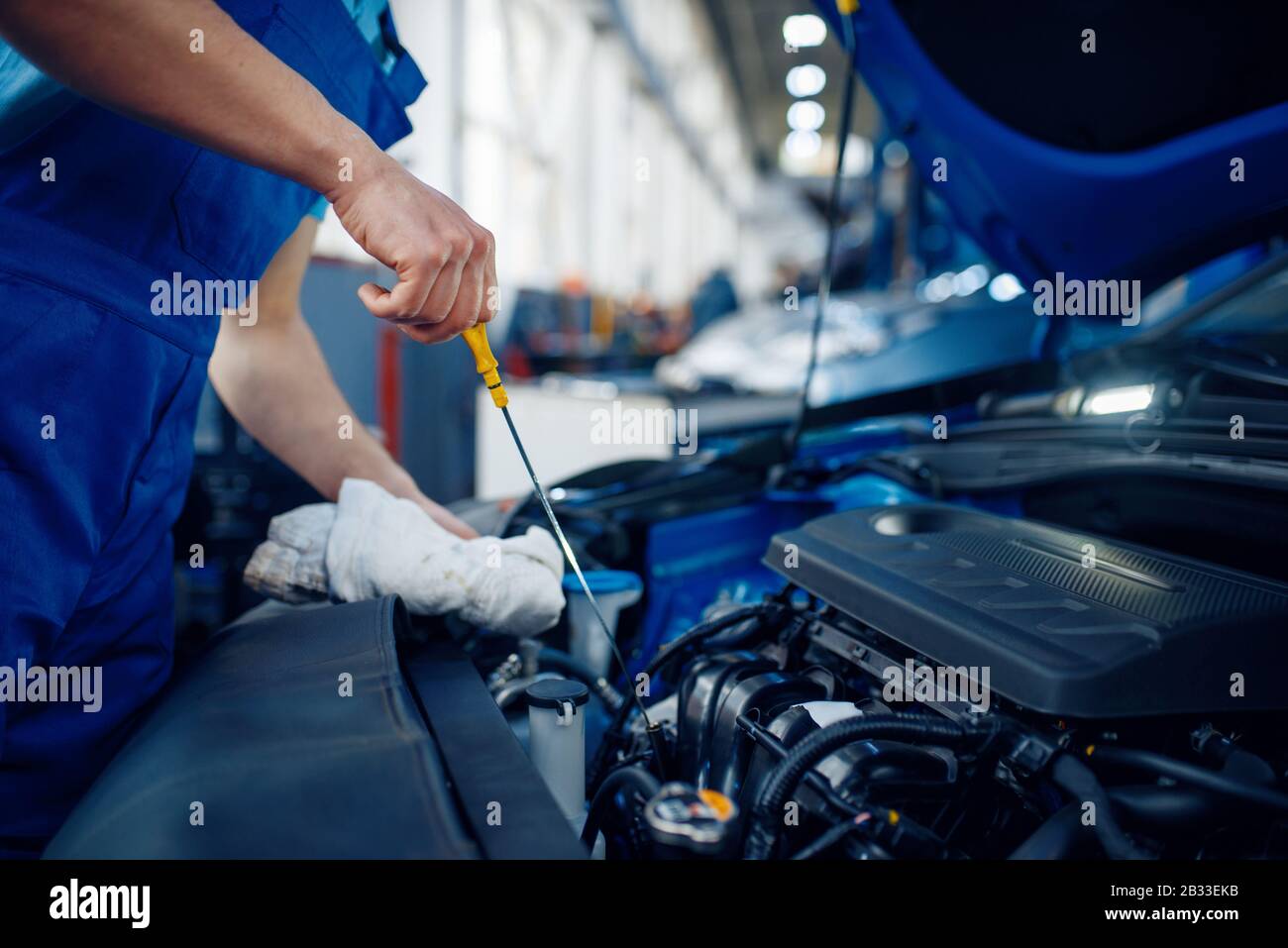 Worker checks the engine oil level, car service Stock Photo Alamy
