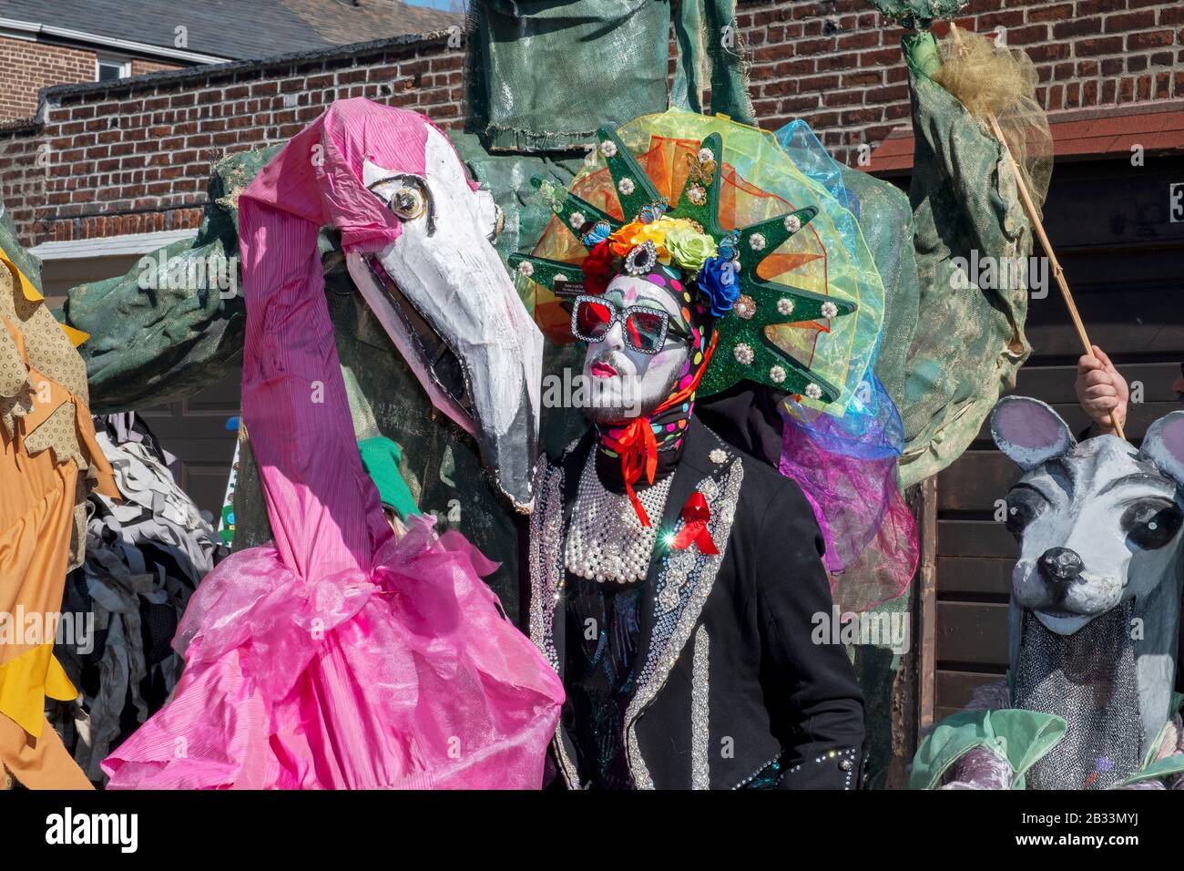 Sister Lotti Da, a performance artist and member of the Sisters of Indulgence poses with large oversized puppets. In Sunnyside, Queens, New York City. Stock Photo