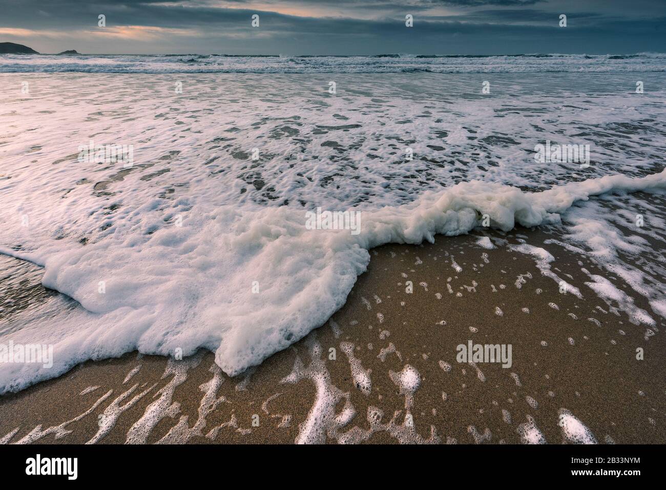Incoming tide on a cold chilly evening at Fistral Beach in Newquay in Cornwall. Stock Photo