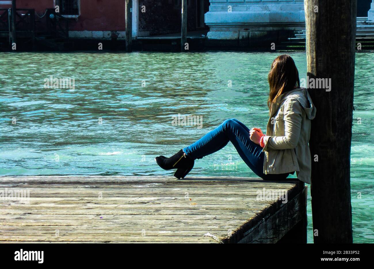 Girl sitting near the river Stock Photo - Alamy