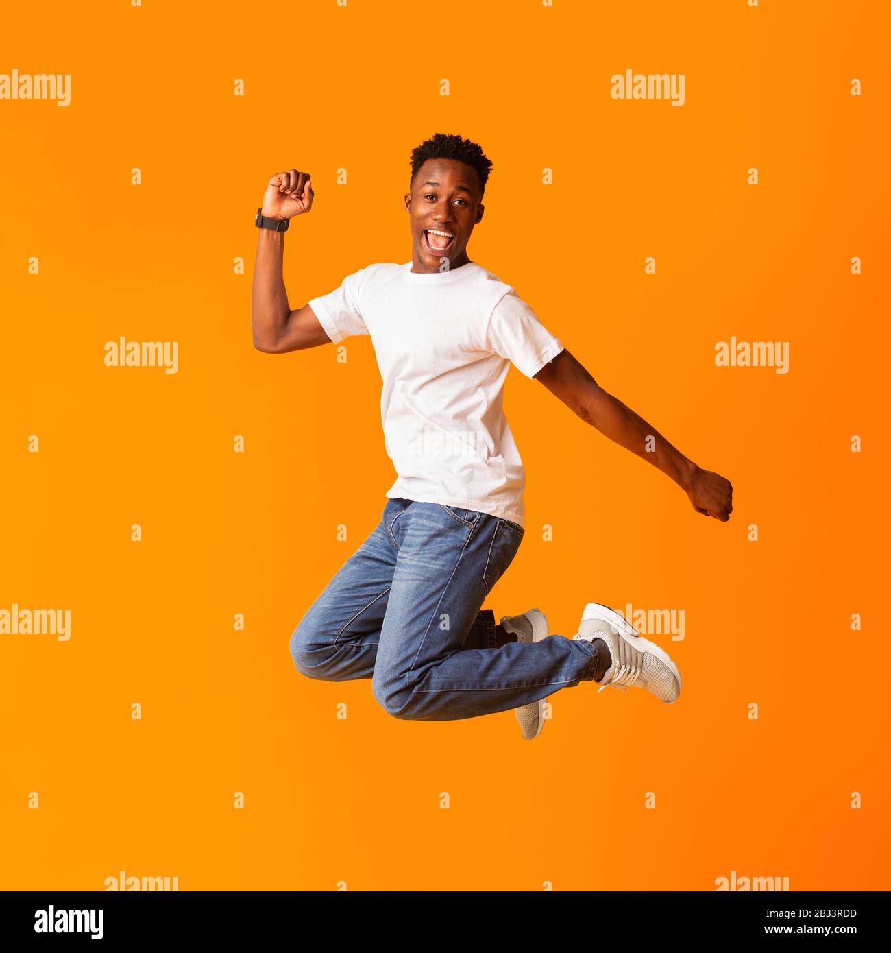Excited screaming african man jumping while celebrating Stock Photo