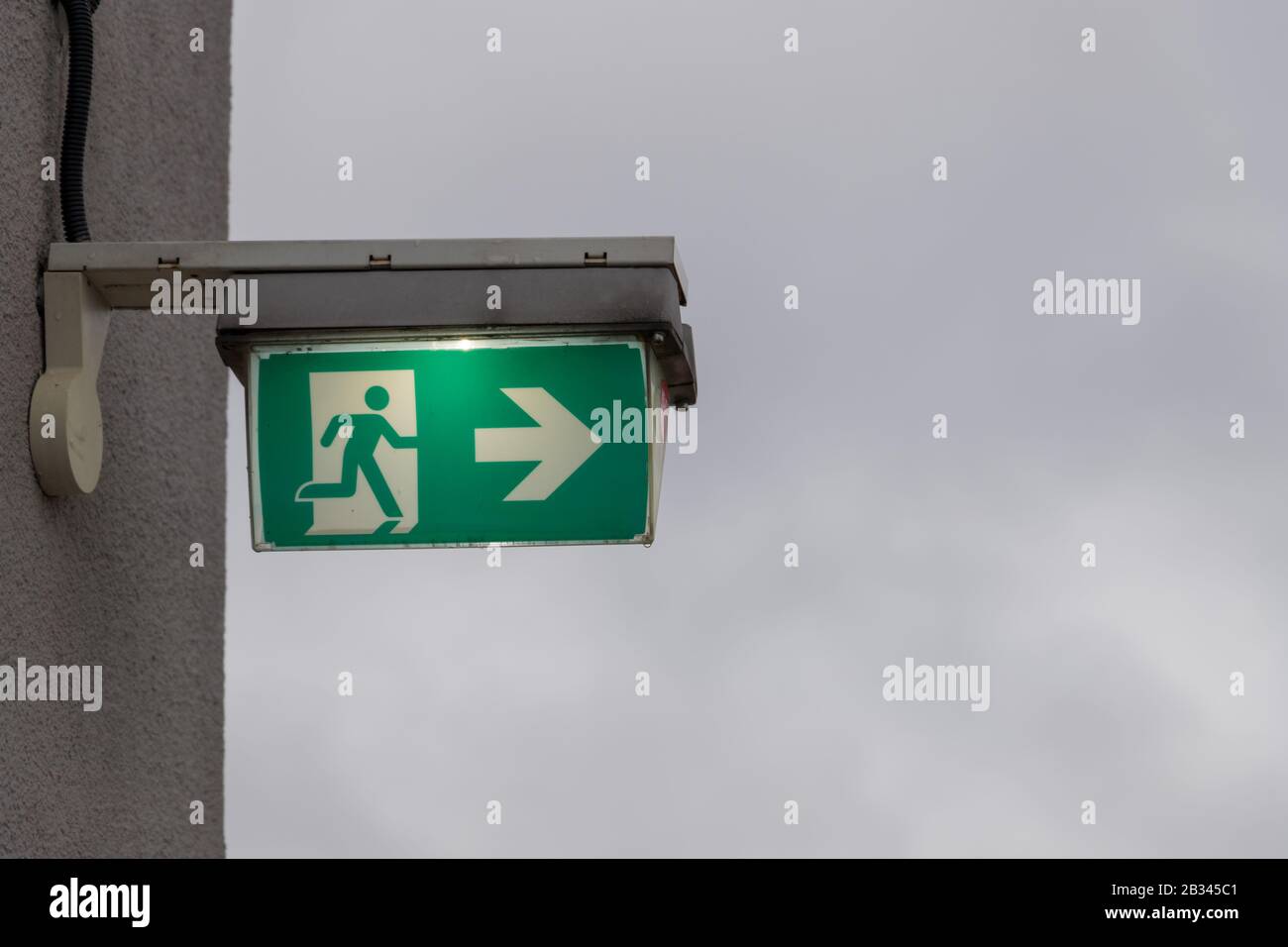 this sign on a wall shows the escape route with an arrow Stock Photo