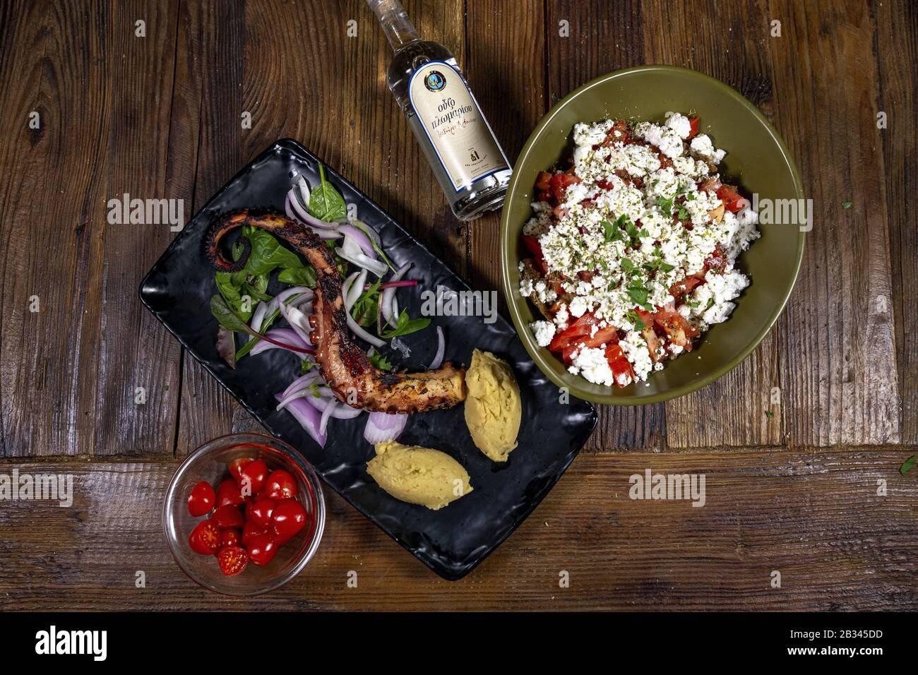 THESSALONIKI, GREECE - Feb 17, 2020: An overhead closeup shot of various seafood and salad dishes with feta cheese and tomato, roasted octopus and Plo Stock Photo