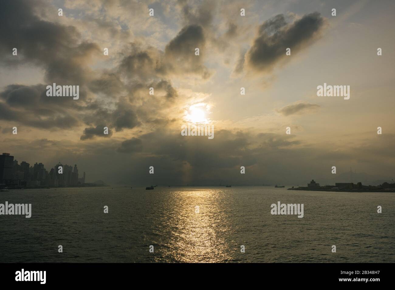 Beautiful scenery of the sunset reflecting on the peaceful sea under a ...