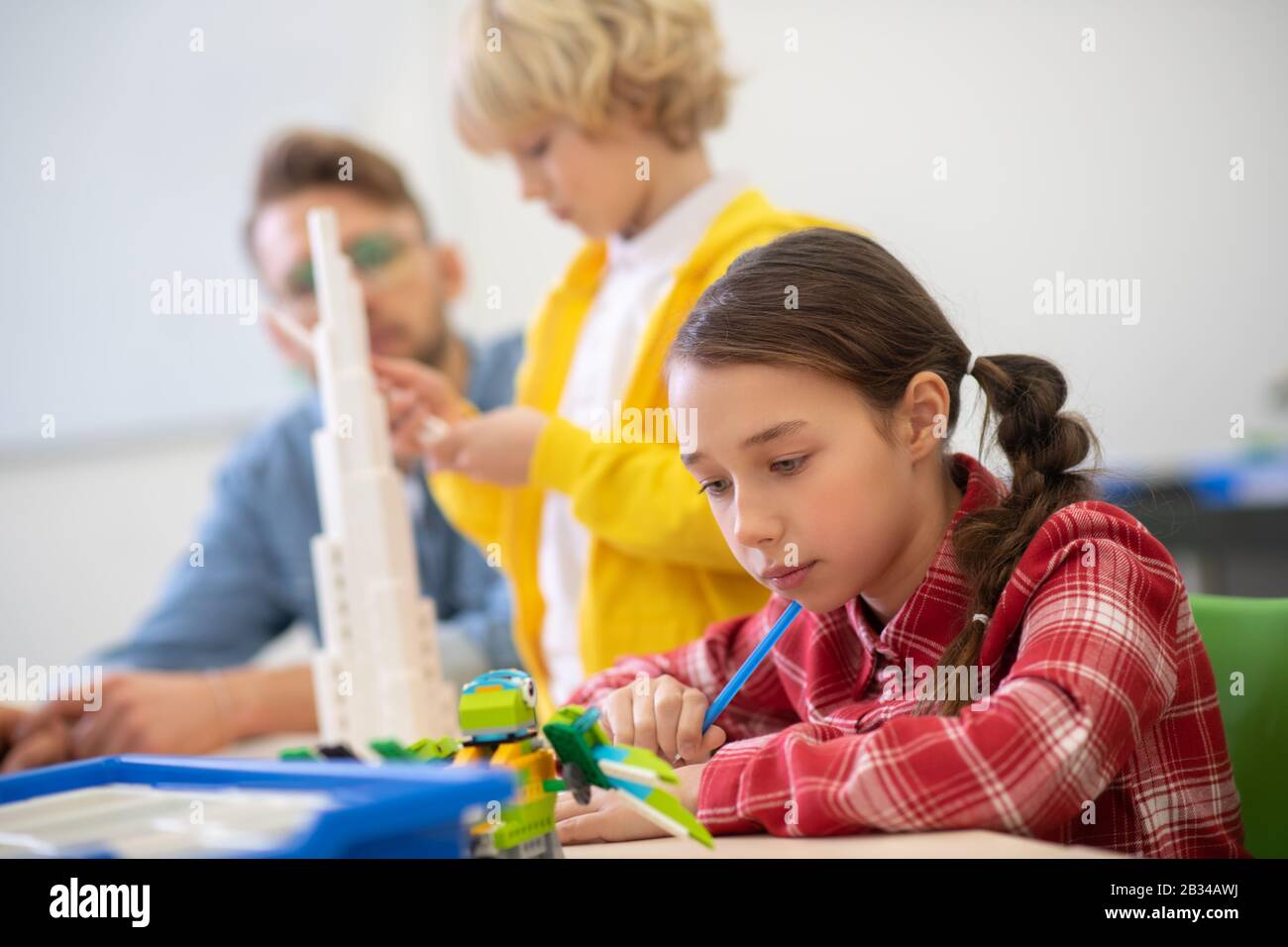 Girl looking at buildable bird, boy building a tower Stock Photo