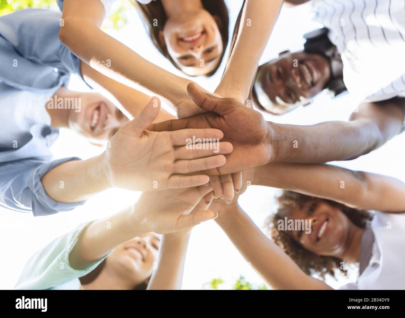 Student Friendship. Portrait of happy university friends stacking hands together Stock Photo