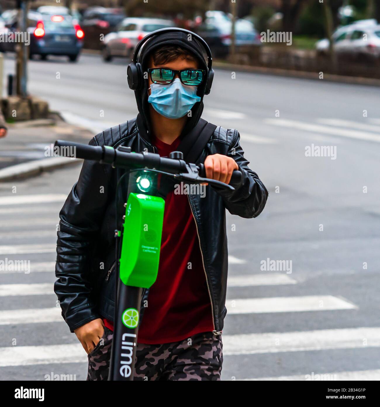 Covid-19 flu disease virus spreading in Europe. Teenager with lime scooter  wearing sunglasses and medical mask on face in Bucharest, Romania, 2020  Stock Photo - Alamy