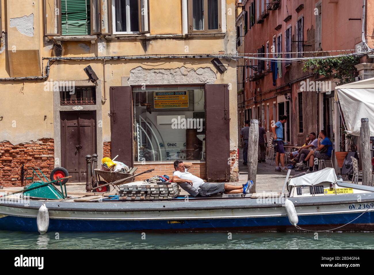 Builder taking a rest on barge, Venice, Italy Stock Photo